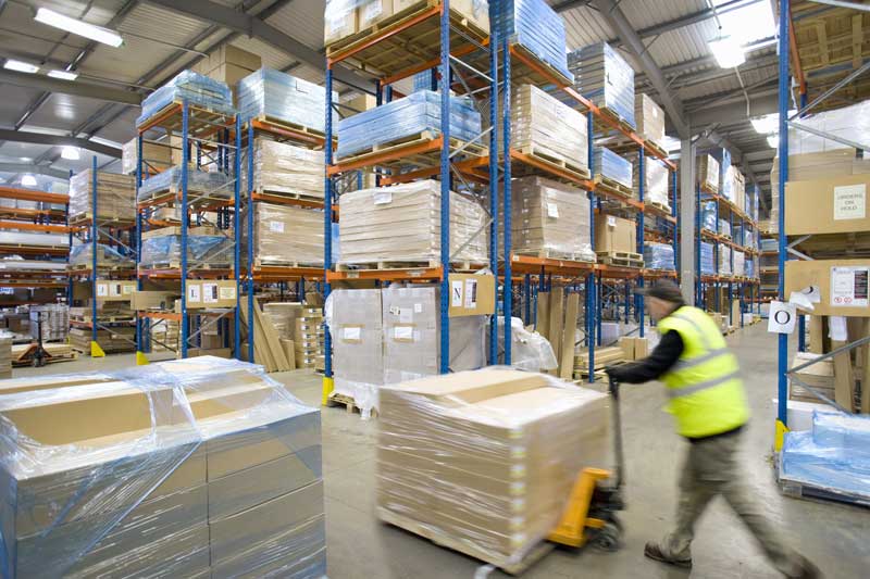 Worker moving pallets in a warehouse